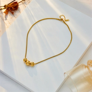 Collana minimalista in titanio placcato oro 18 carati con tre sfere graduate e catena snake