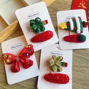 Détail d'un lot de barrettes de Noël avec nœuds et paillettes sur carte de support