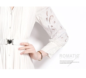 Détail de la robe blanche avec broderie dentelle et ceinture à boucle cœur en métal