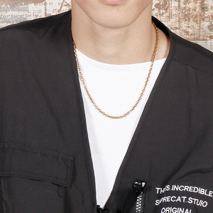Close-up of a minimalist golden stainless steel O-link chain worn on a model's neck