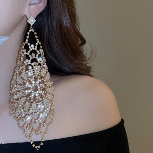 Detailed view of oversized diamond tassel earrings with intricate geometric hollow design