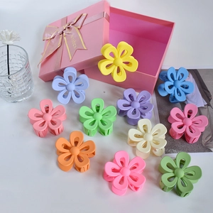 Flat lay of colorful flower-shaped matte hair claws in a variety of vibrant spring colors