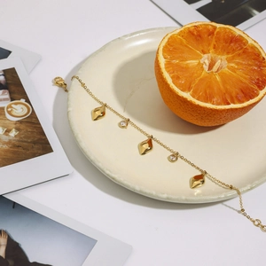Detail of 18K gold butterfly heart bracelet with zircons on elegant ceramic tray