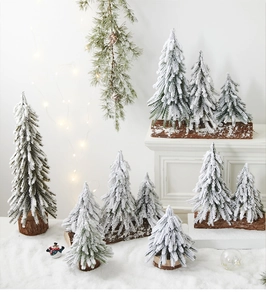 Mini frosted Christmas trees with snowy flocking and rustic wood bases for desk decor