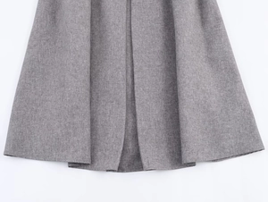 Detailed close-up of grey herringbone suit skirt hem showing fine woven fabric texture