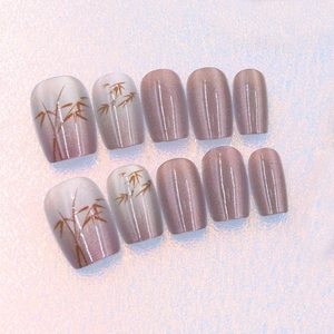 Détail de faux ongles œil-de-chat à motif bambou en finition pailletée rose mauve élégant