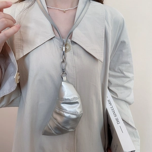 Détail du mini sac croissant argenté porté comme un collier croisé élégant