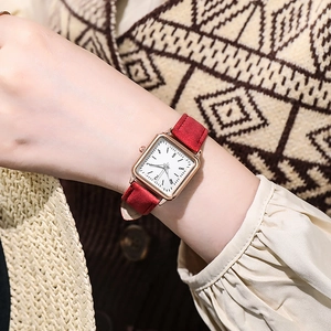 Detail of elegant square women watch with luminous dial and red suede leather strap