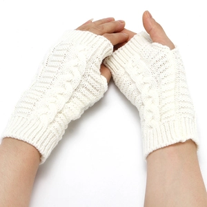 Close-up of white knitted fingerless gloves showing soft acrylic texture and weave