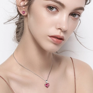 Silver necklace and heart-shaped red zircon earrings set on a female model
