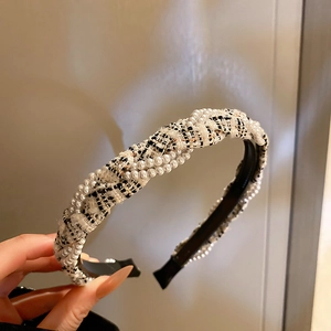 Detailed shot of tweed fabric intertwined with pearls on a luxury style headband