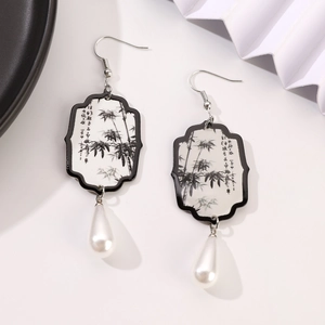 Detail view of fan-shaped earrings with ink bamboo pattern and white pearl drop