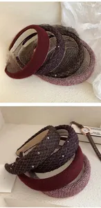 Detailed close-up of thick French tweed headbands in burgundy and plaid woven texture
