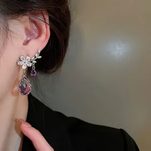Elegant floral branch drop earrings with purple crystals and silver needles on model
