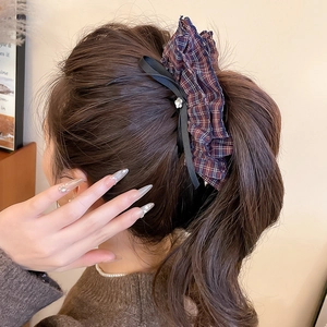 Detail of red and blue plaid bow hair clip with rhinestone on model hair