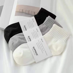 Tre paia di calzini corti in misto cotone nero, grigio e bianco con fascia di carta
