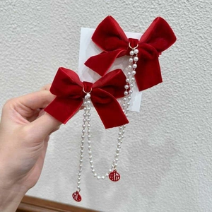 Detail of red velvet bow hair clips with pearl chains and Fu character charms