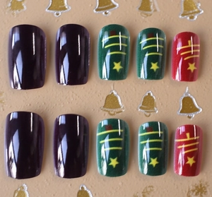 Detailed macro view of Christmas themed nail tips in deep purple red and green tones