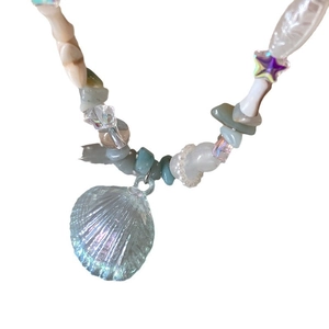 Beaded necklace with pearls, seashells, and starfish charms on a white background