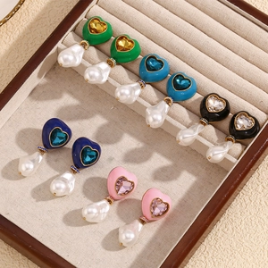 Baroque pearl heart earrings with colorful zircon inlay in a velvet jewelry tray