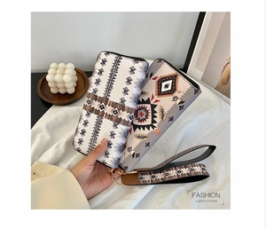 Detail of two lady purses with geometric tribal patterns and a convenient wrist strap