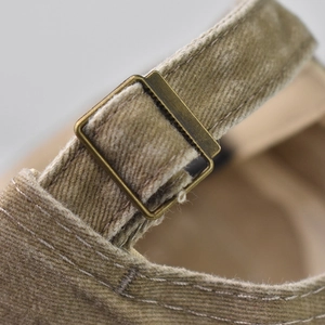 Macro detail of washed cotton baseball cap featuring vintage bronze adjustable metal buckle