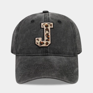 Close-up of leopard print letter J embroidery on washed black cotton baseball cap