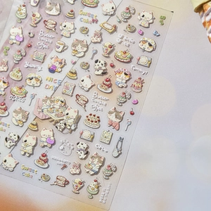 Detail of 3D embossed nail art stickers featuring cute cats and sweet dessert patterns