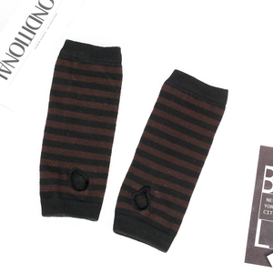 Detail of striped knitted arm warmers with thumb holes on a stylish white background