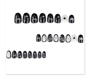 Detail of Gothic black Y2K press-on nails with 3D bows, hearts, and pearl accents
