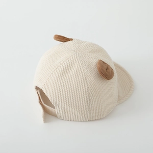 Détail du tissu en velours côtelé doux et des oreilles d'ours en peluche sur la casquette