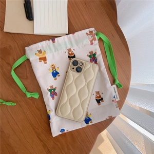 Close-up of cotton drawstring bag with cute bear prints and a quilted wave phone case