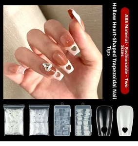 Macro detail of coffin fake nails with heart cutouts and clear rhinestone decoration