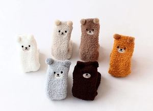 Détail de chaussettes en polaire corail pour bébé avec oreilles d'ours en 3D