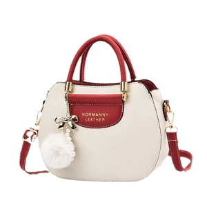 Chic burgundy and off-white shell handbag with plush ball and pearl pendant charms