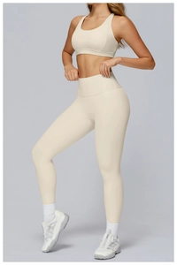 Detail of high-waisted yoga leggings and sports bra set in cream matte fabric
