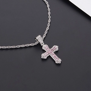 Vue macro du pendentif croix en argent avec gemmes roses et détails en zircon blanc