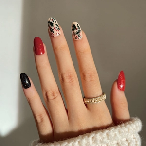 Christmas theme press-on nails featuring red, black glitter, and holly berry hand-painted designs