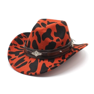 Close-up of cow print cowboy hat with brown leather band and silver metal hardware