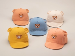 Flat lay of colorful baby baseball caps with bear embroidery and cute 3D ears