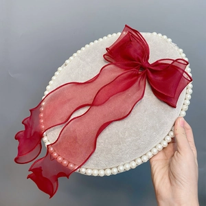 Detail of dark red organza double layer bow hair clip with elegant long trailing ribbons