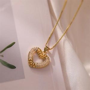 Detailed shot of gold heart pendant with sparkling crystals on elegant silk background