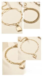 Close-up of 18K gold-plated bracelets featuring heart charms and padlock pendants