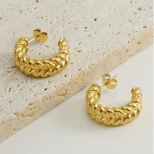 Detailed view of 18k gold plated stainless steel croissant earrings on stone surface