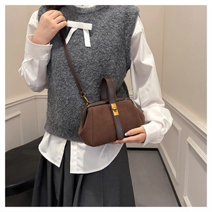 Retro dark brown shell bag with matte finish shown on model in academic style