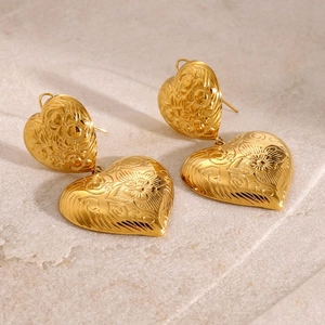 Vintage heart shaped gold drop earrings with intricate floral relief and engraved patterns