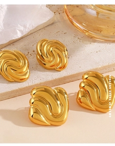 Detailed macro view of 18K gold plated stainless steel spiral and wavy hoop earrings