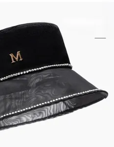 Detail of black wide brim bucket hat with sheer mesh edge and sparkling rhinestone trim