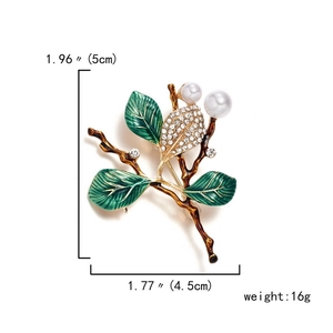 Detailed view of floral brooch with green enamel leaves, pearls and size dimensions