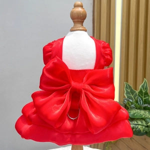 Close-up of red pet wedding dress featuring a large bow and a metal D-ring leash attachment